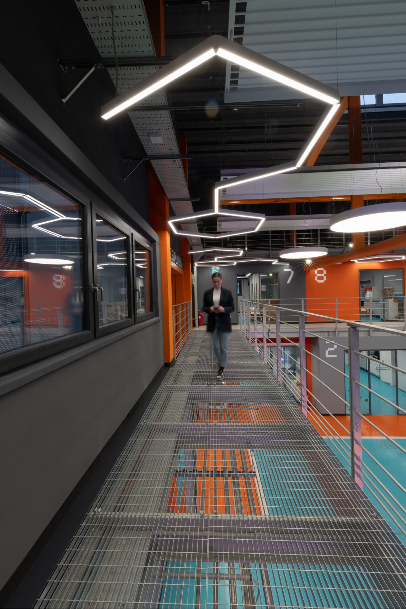 Foto di una persona che cammina in un magazzino illuminato da lampade a sospensione moderne e innovative