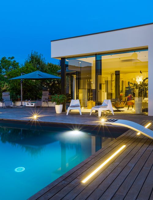 Foto dell'esterno illuminato di una villa con piscina