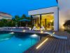 Casa con piscina dall'esterno, con luce da terra neon a bordo piscina