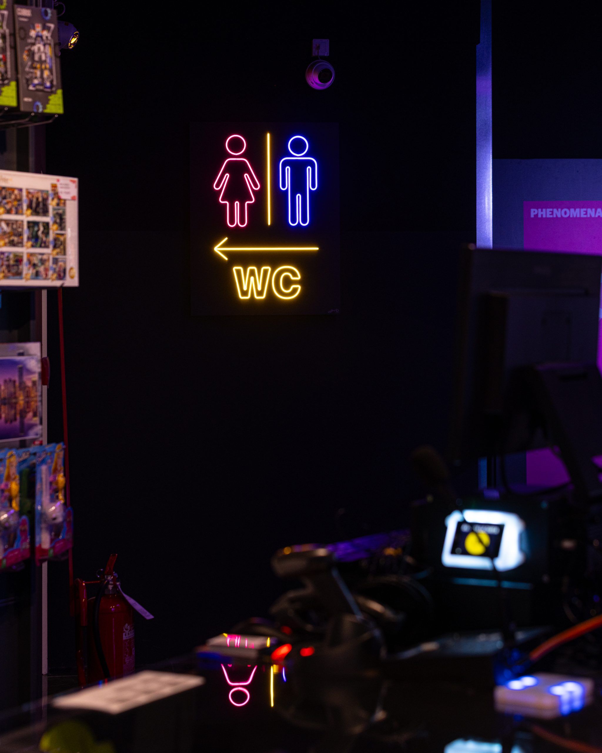 Insegne Toilette con LED colorati creano continuità con l'illuminazione della sala giochi.
