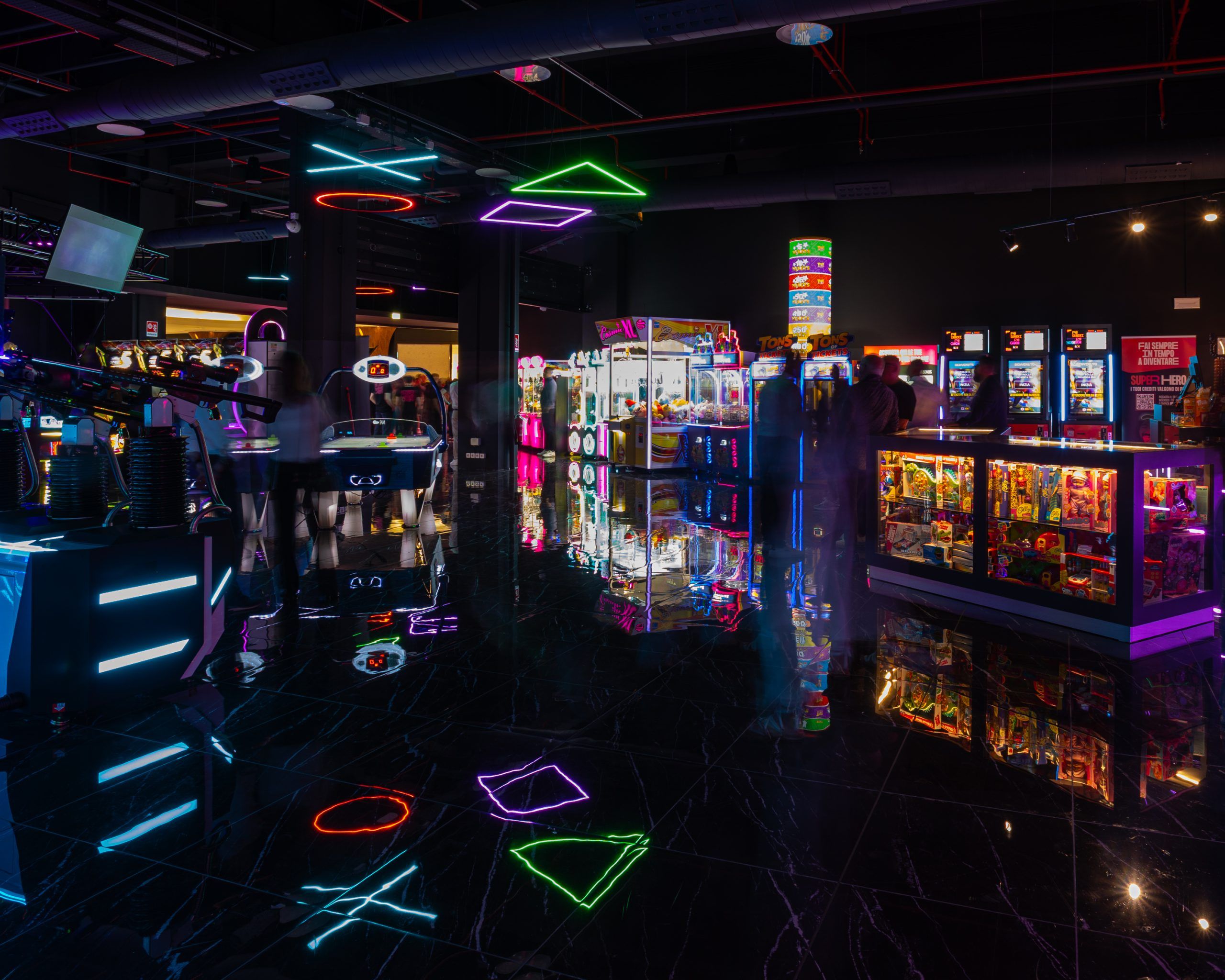 Veduta d'insieme della sala giochi con installazione di luci LED colorate con la forma dei simboli del joystick.