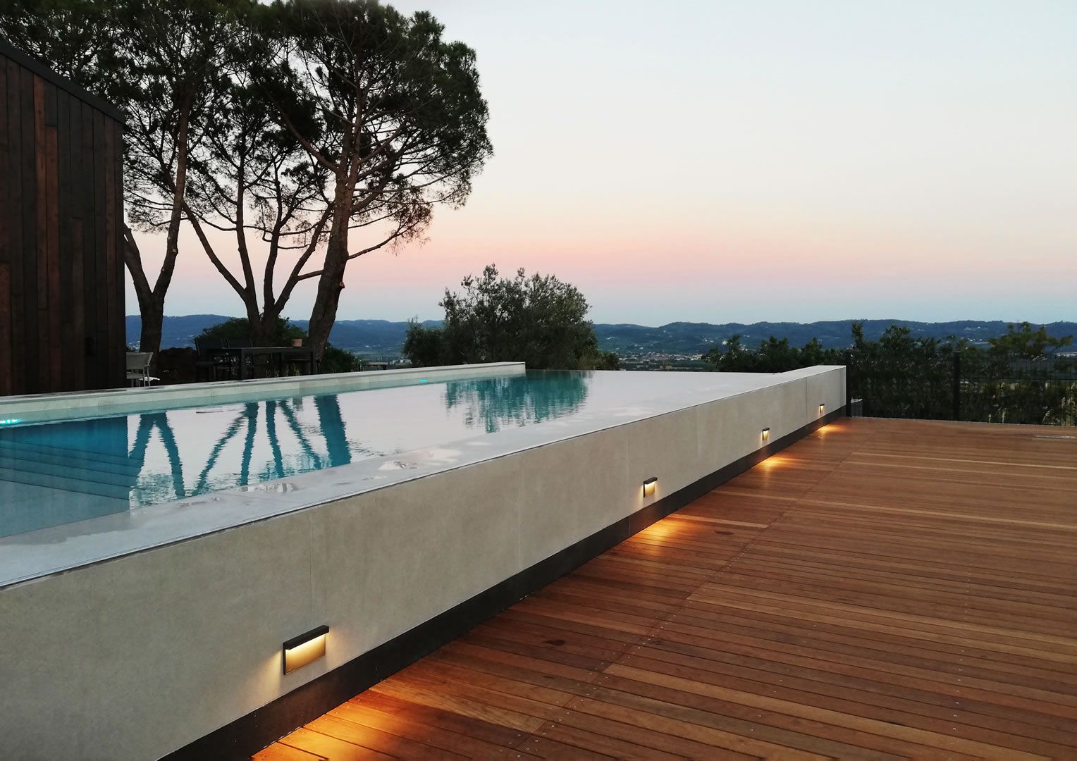 Faretti da esterno per piscina illuminano un pavimento in legno