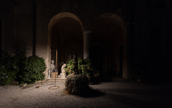 Lampada da terra che illumina delle statue e delle siepi