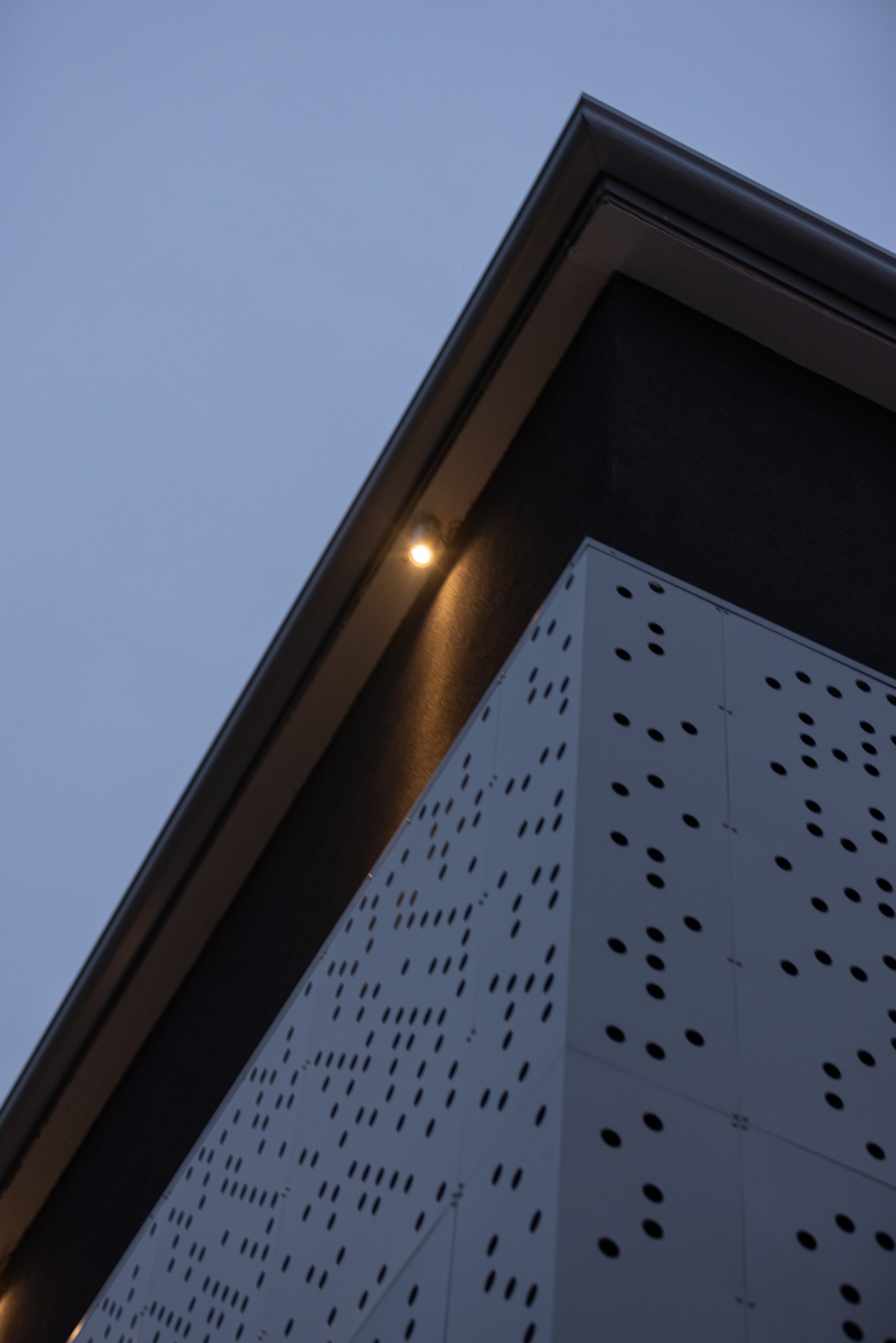 faretto da esterno che illumina la parete esterna di un edificio dall'alto verso il basso