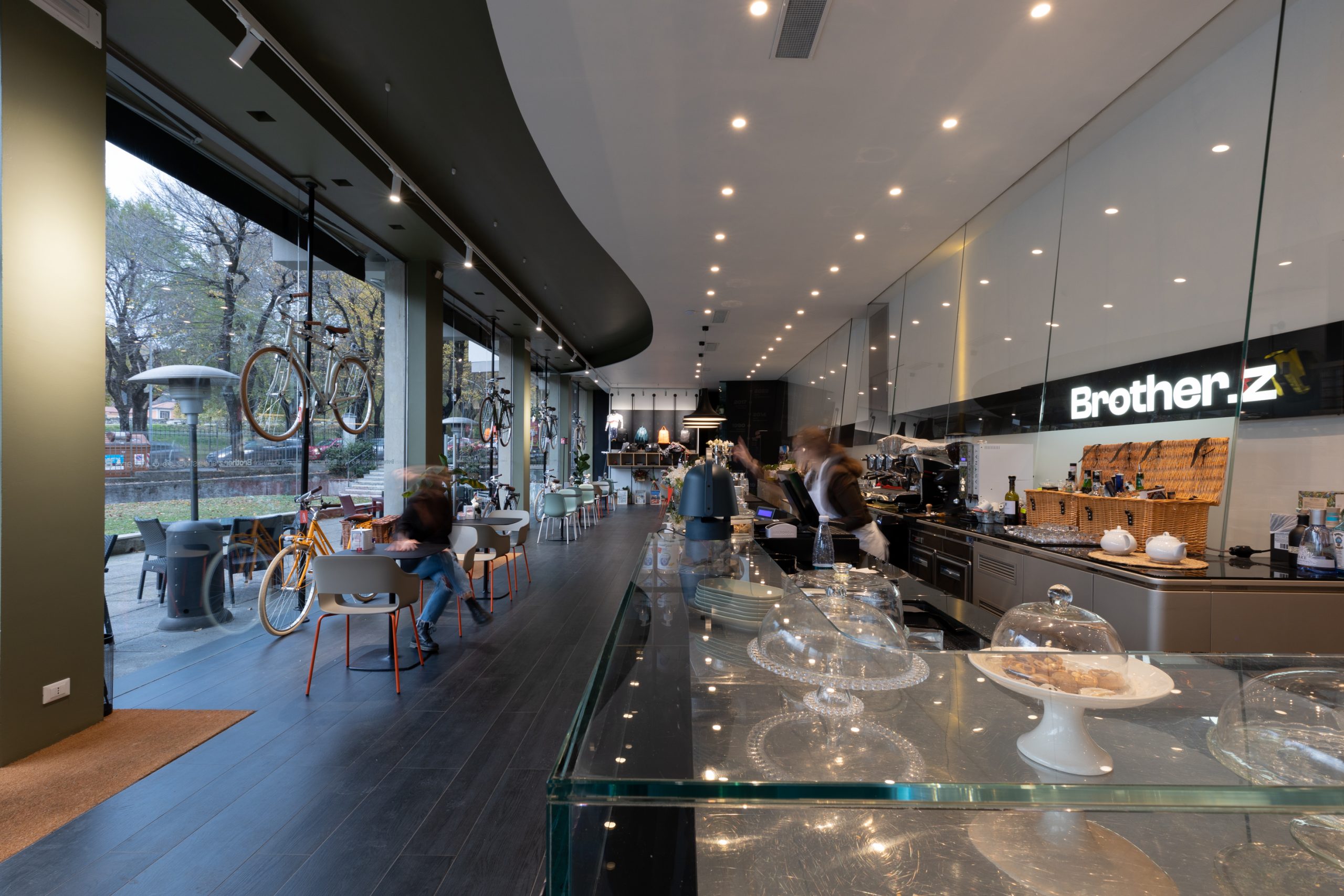 Foto di un locale/caffetteria che mostra il bancone on le cose da mangiare e l'illuminazione data dai faretti sul soffitto