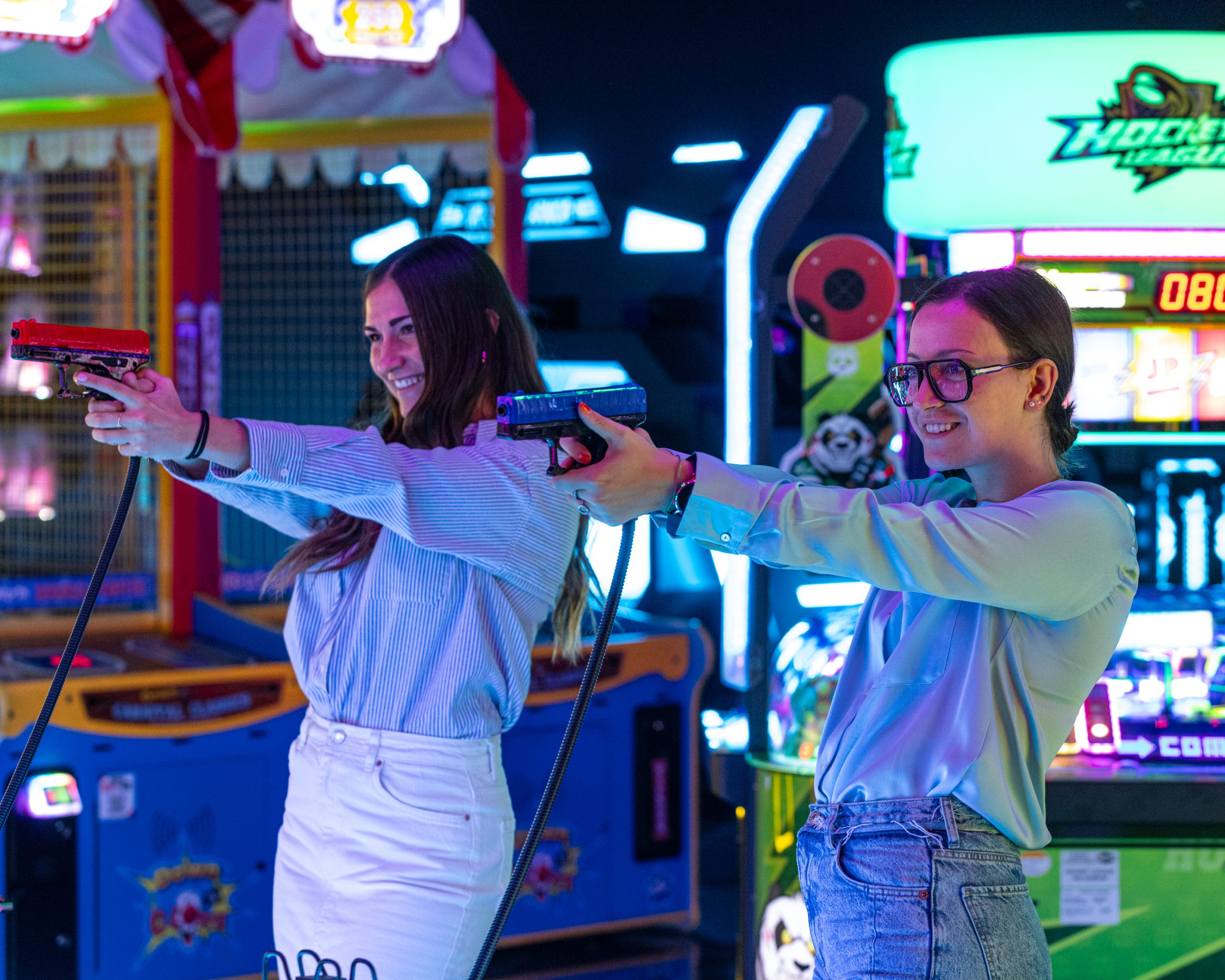 Giocatori immersi nell'atmosfera unica della sala giochi LOG, dove l'illuminazione scenografica a LED diventa parte integrante dell'esperienza di gioco.