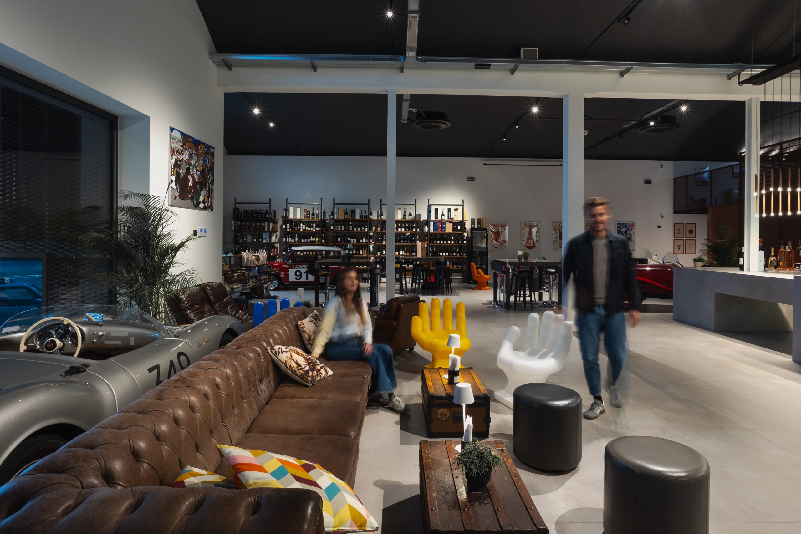 Illuminazione zona divani del bar enoteca in ex capannone industriale