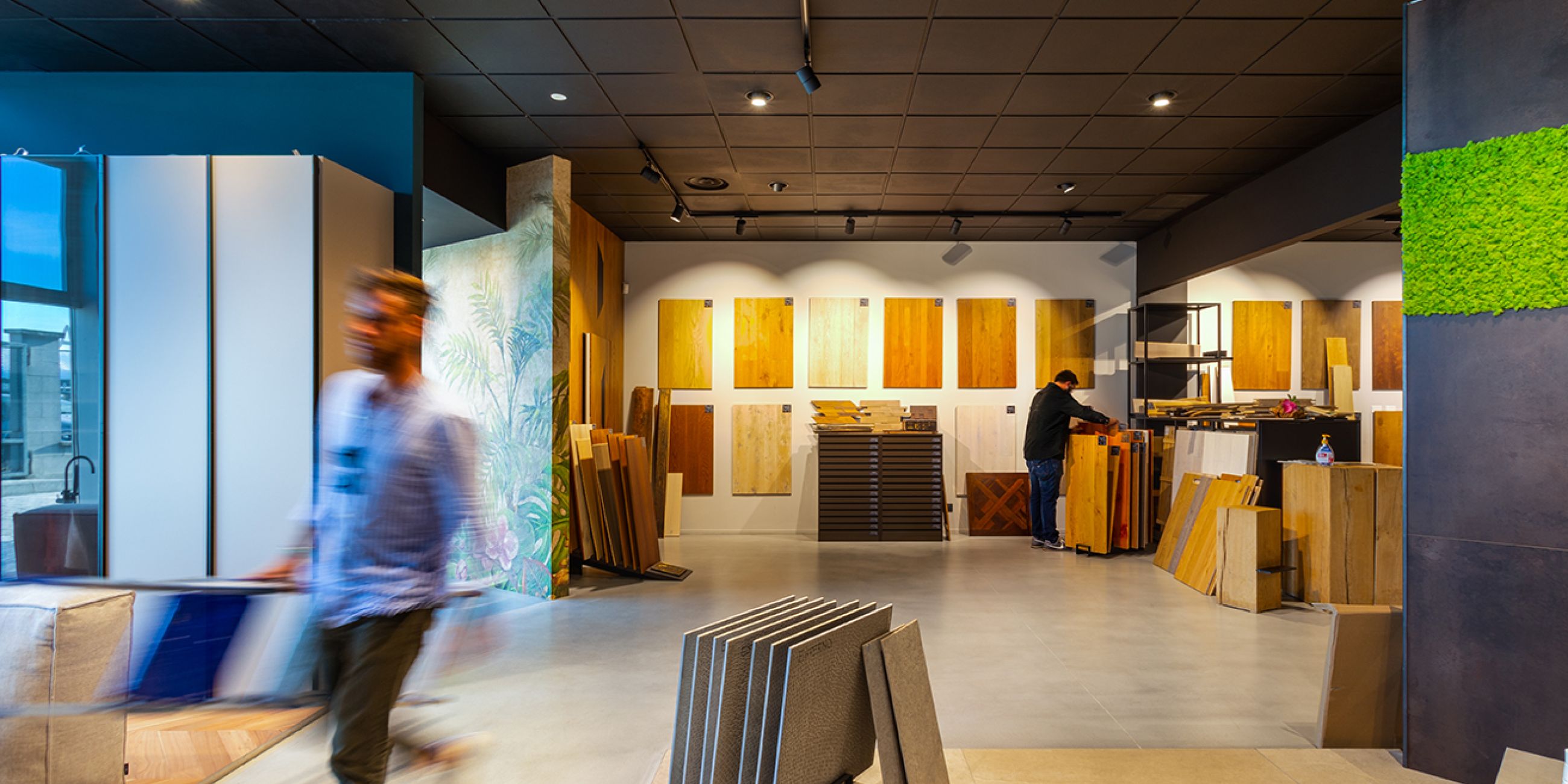 Persona che cammina in un salone espositivo di prodotti in parquet