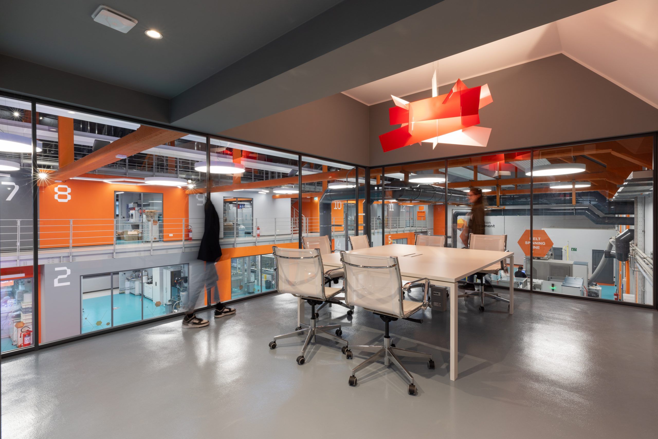 Foto di una sala riunioni, illuminata da una lampada a sospensione moderna color rosso