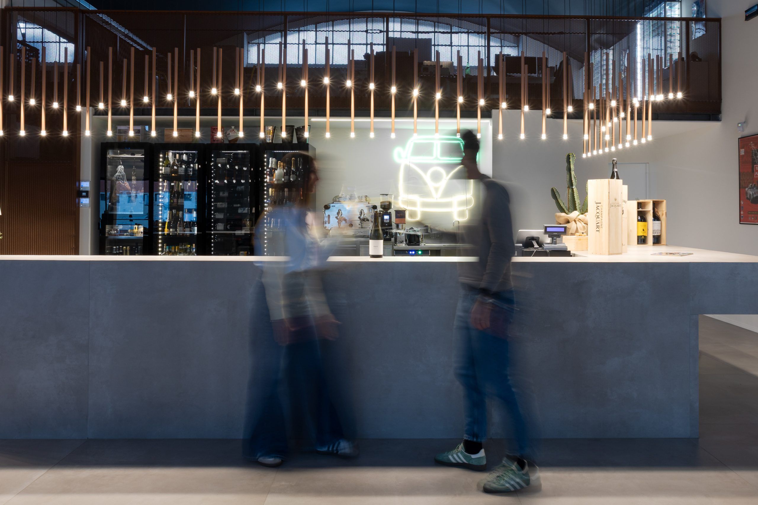 Bancone bar enoteca illuminato con una composizione di luci a sospensioni