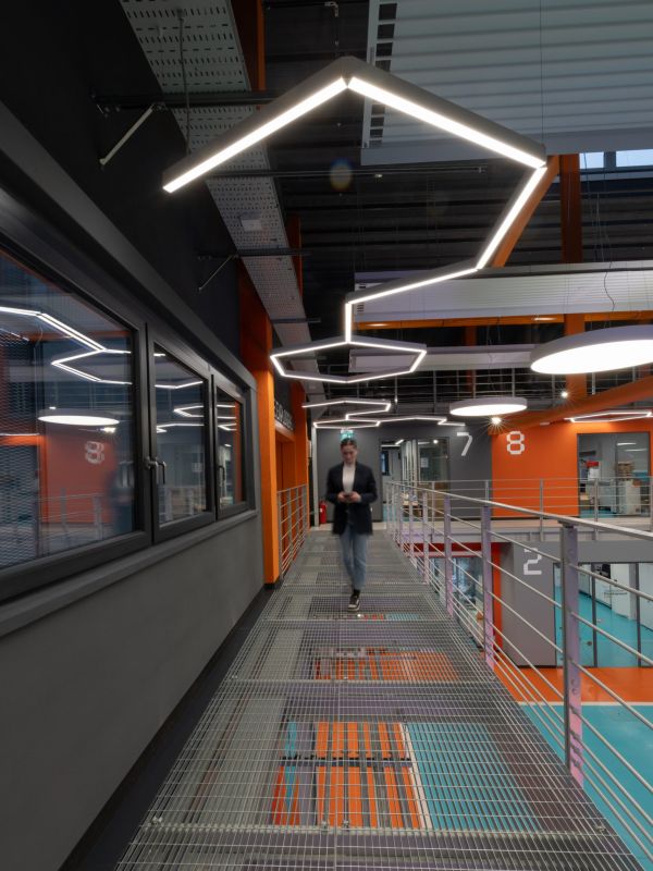 Foto di una persona che cammina in un magazzino illuminato da lampade a sospensione moderne