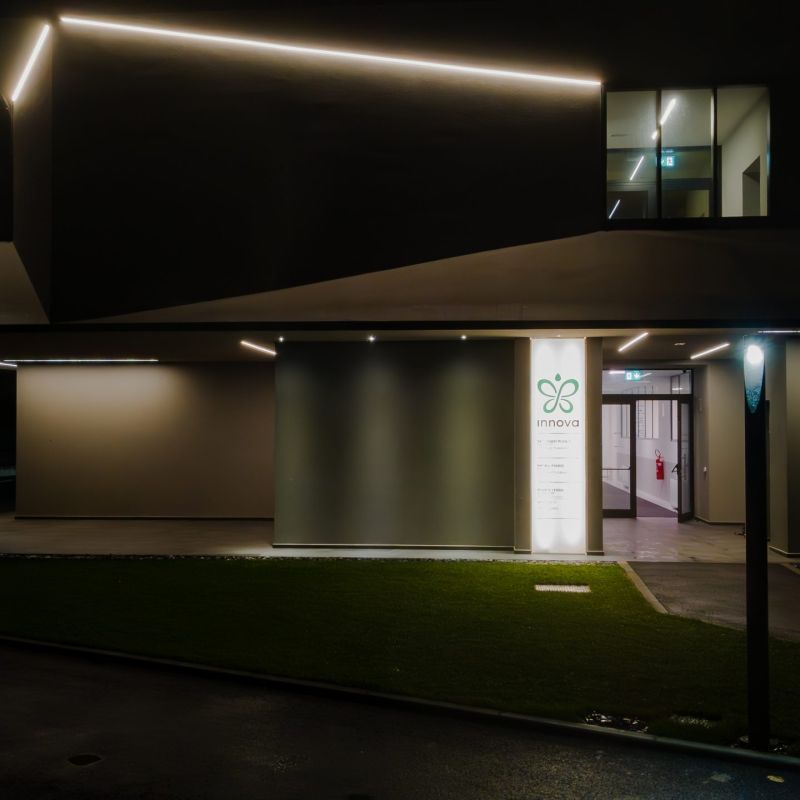 Facciata di uno stabilimento industriale con in primo piano un elemento illuminotecnico urbano 