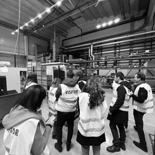 Gruppo di persone con giubbotti catarifrangenti in visita aziendale