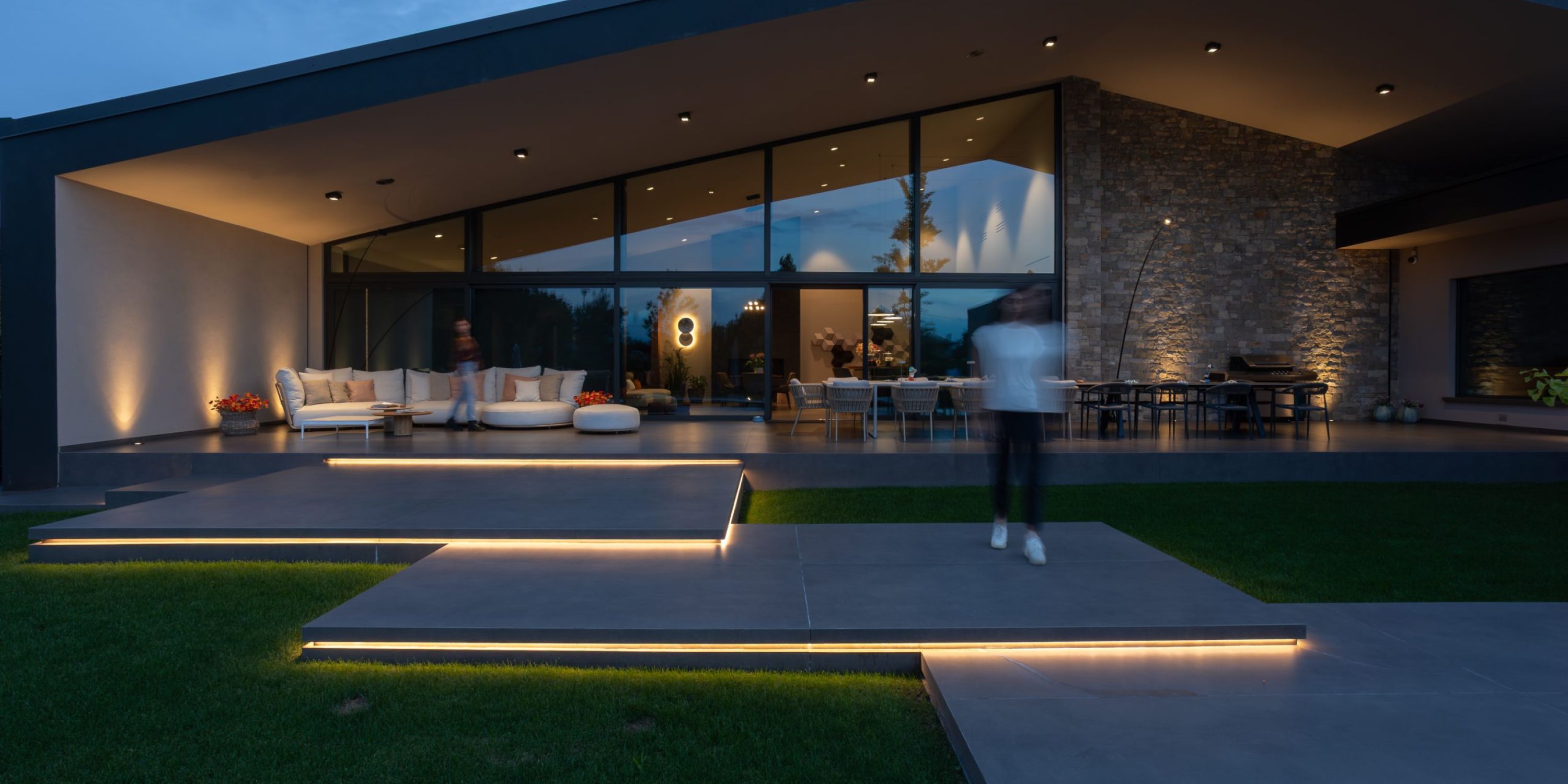 La zona pranzo di un moderno appartamento illuminato con sospensione in vetro.