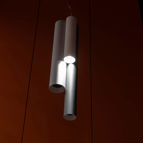 Lampada a sospensione formata da tre tubi cilindrici 