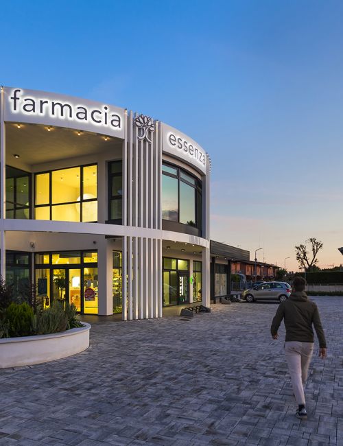 Facciata di una farmacia con un uomo che cammina