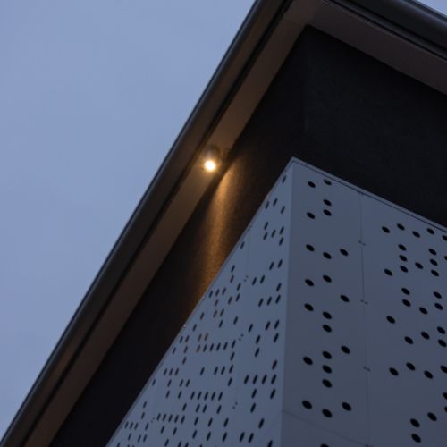 faretto da esterno che illumina la parete esterna di un edificio dall'alto verso il basso