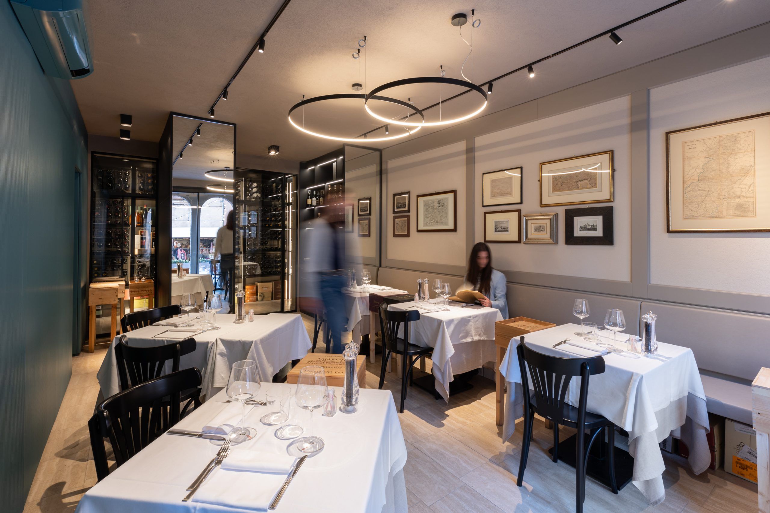 Sala di una trattoria illuminata da luci a sospensione