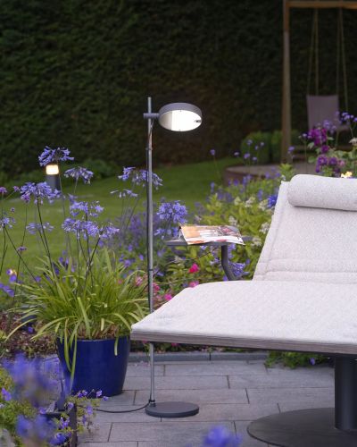 Lampada da terra che illumina una sorta di sdraio in giardino