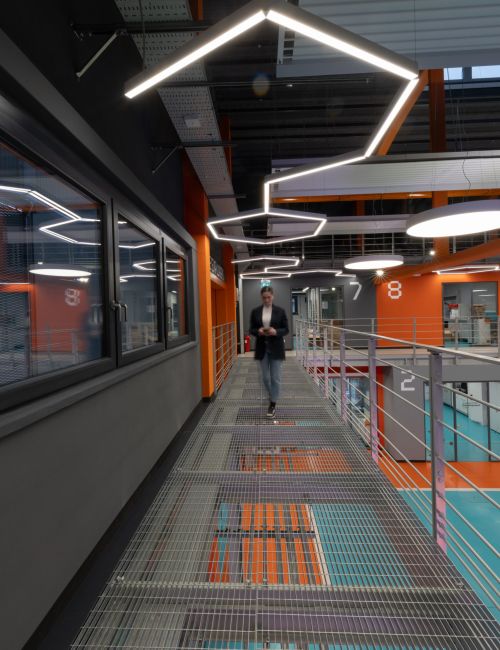 Foto di una persona che cammina in un magazzino illuminato da lampade a sospensione moderne e innovative