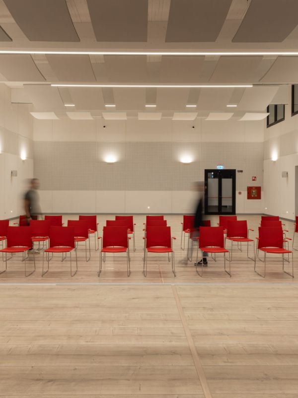 Aula magna illuminata con due persone che camminano